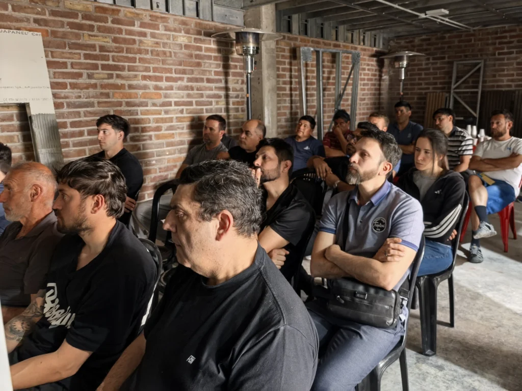 Asistentes siguen la charla técnica sobre cubiertas y paneles aislantes en el salón de Grupo ExtraBrut