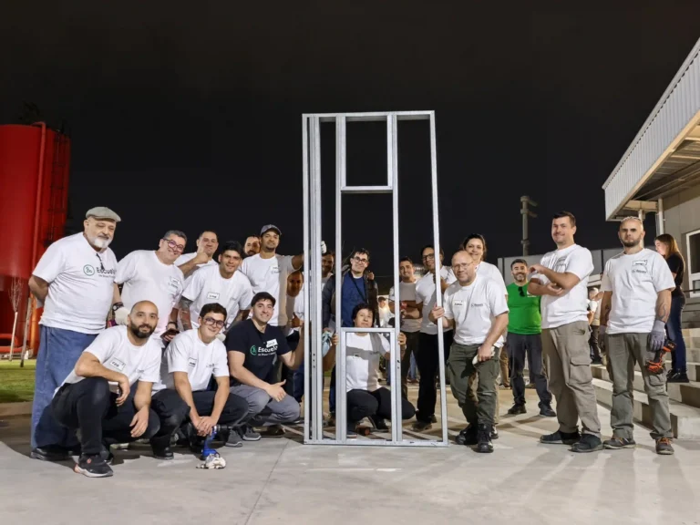 Equipos del taller junto a un panel de steel framing armado, al cierre del primer día