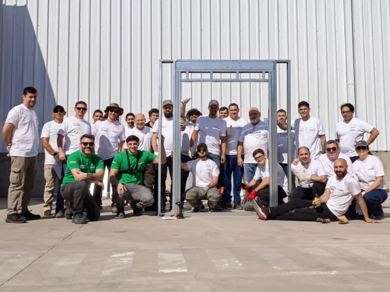 Participantes frente a la estructura de steel framing con abertura montada durante el segundo día