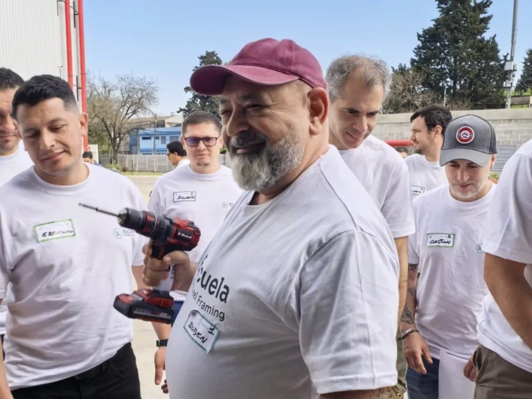 Participante con una atornilladora durante la práctica, rodeado de su equipo