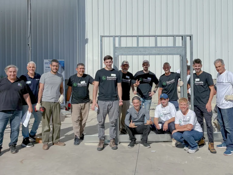 Egresados de la edición de abril frente a un panel de steel framing