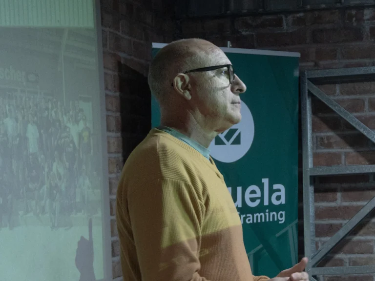 Especialista durante una charla técnica frente al banner de la Escuela de Steel Framing
